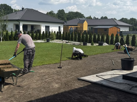 Pracownicy Świata Ogrodów zajmujący się tworzeniem trawnika z rolki